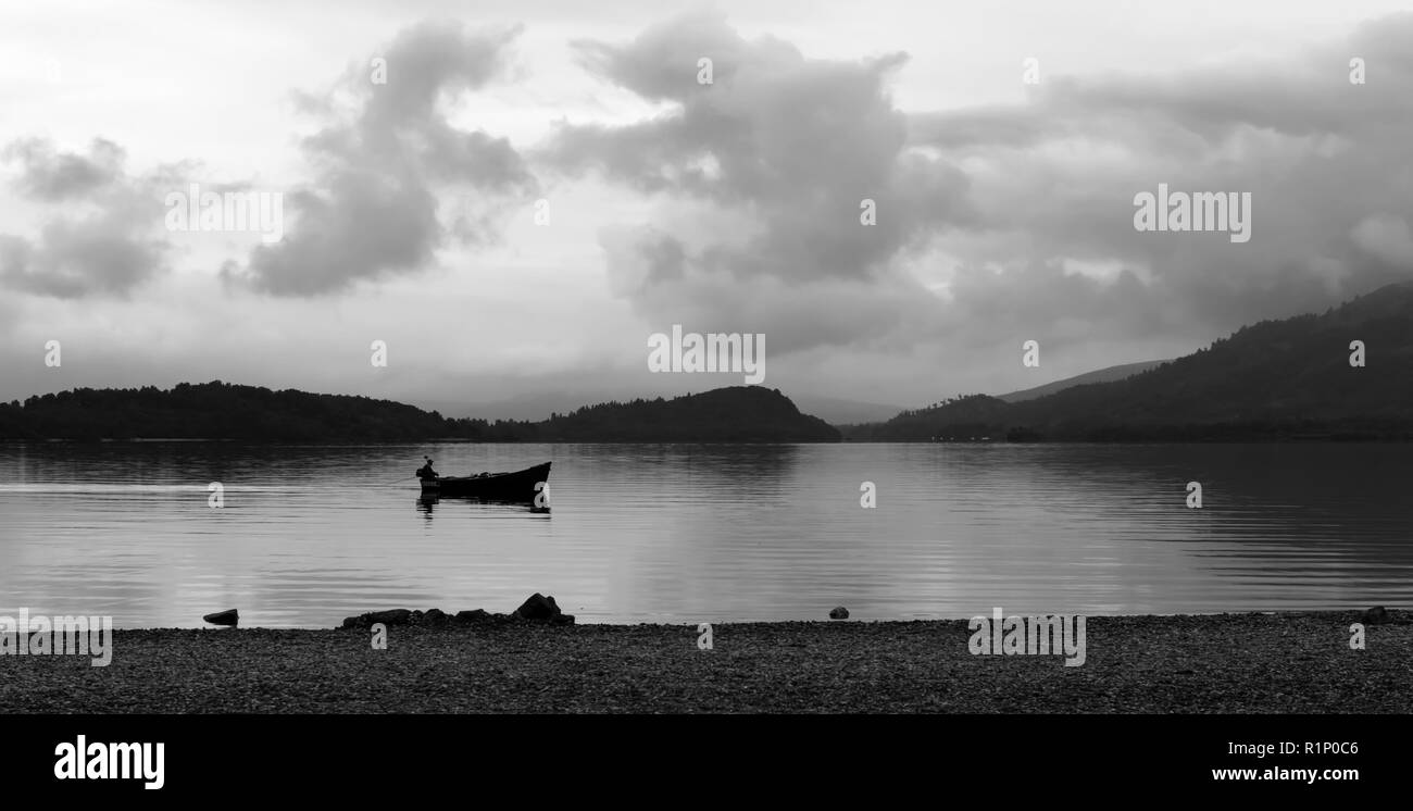 Pescatore nella sua barca sul Loch Lomond Foto Stock