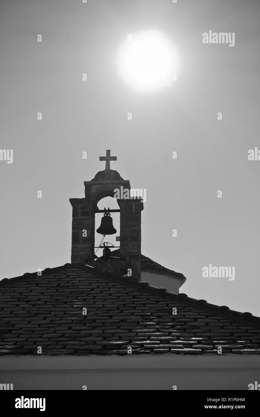 Sun al di sopra del campanile di una piccola chiesa bianca a Skopelos città vecchia, isola di Skopelos, Grecia Foto Stock