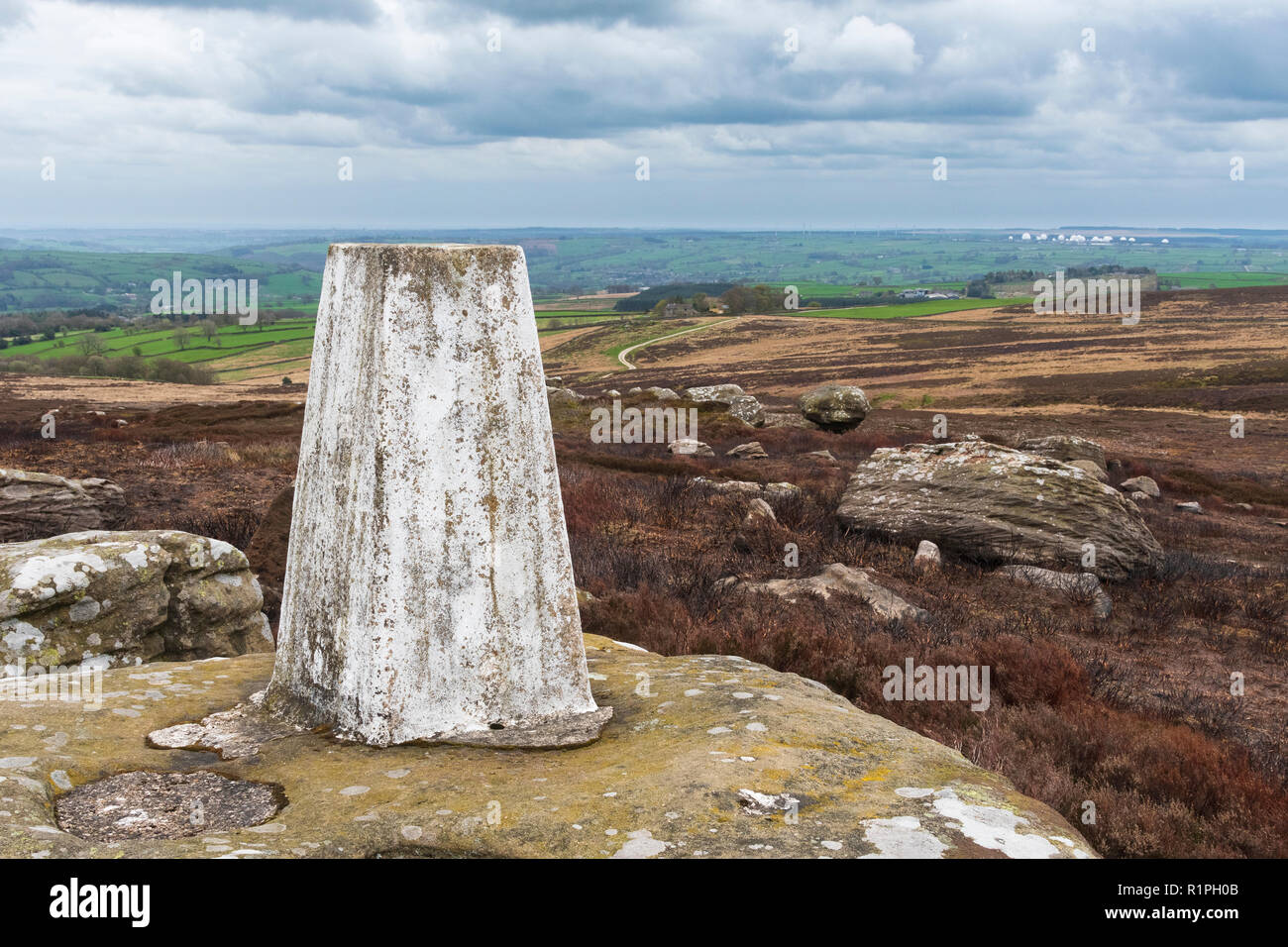 Close-up di Heyshaw Moor punto trig arroccato sulla brughiera affioramento con scenic viste rurali a Menwith Hill - vicino a Harrogate, North Yorkshire, GB, Regno Unito Foto Stock