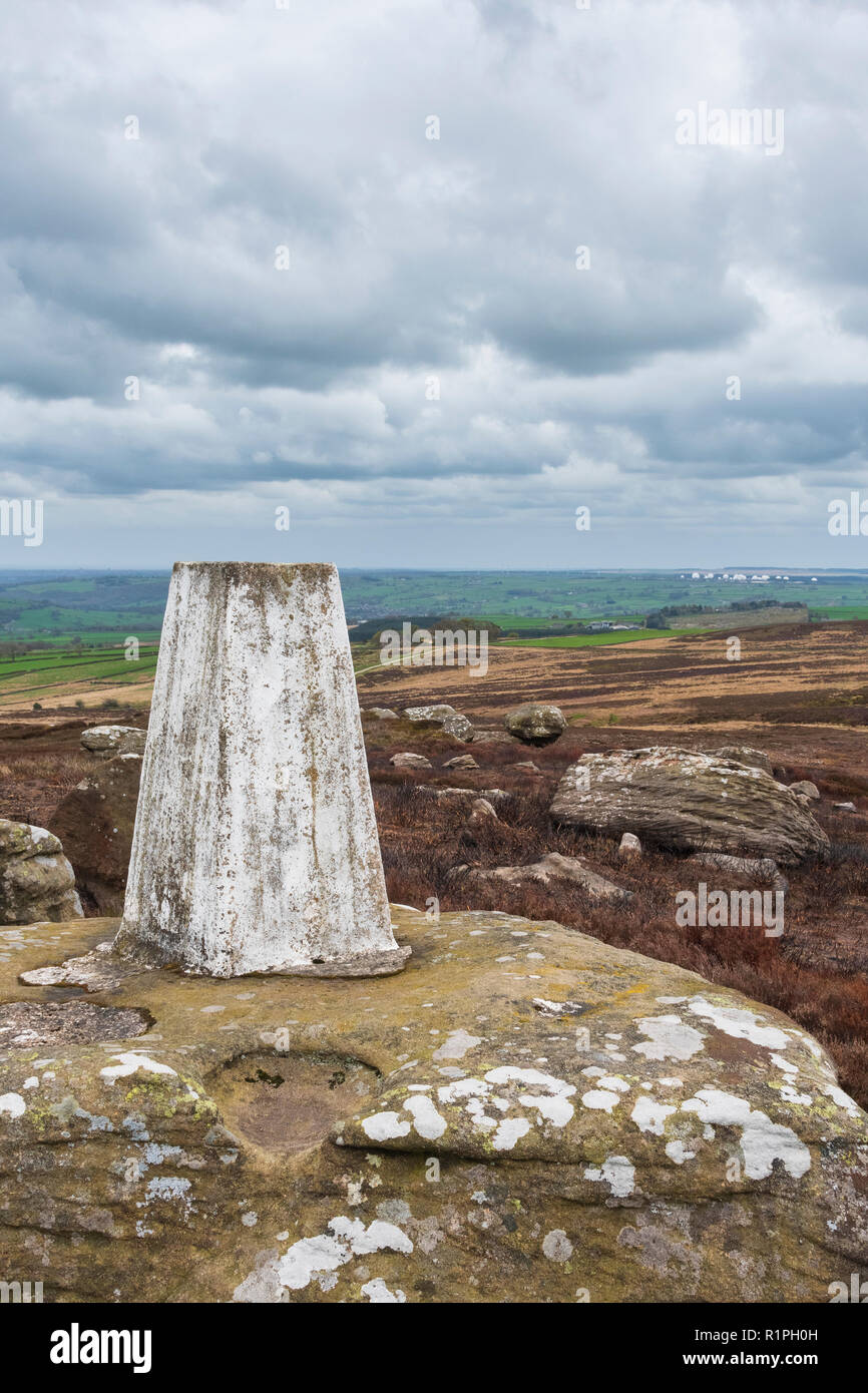 Close-up di Heyshaw Moor punto trig arroccato sulla brughiera affioramento con scenic viste rurali a Menwith Hill - vicino a Harrogate, North Yorkshire, GB, Regno Unito Foto Stock