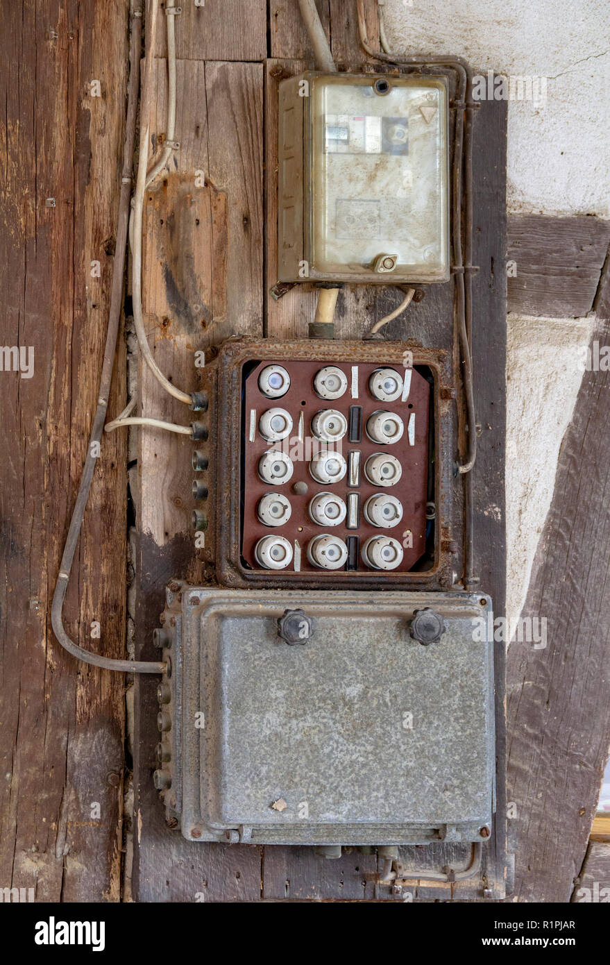 Vecchio elettrico casella di ritaglio su una parete in un ambiente rustico Foto Stock