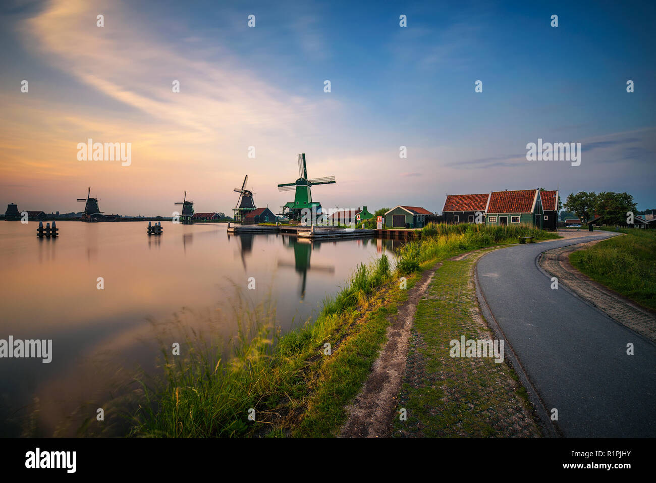 Tramonto al di sopra di case coloniche e mulini a vento di Zaanse Schans nei Paesi Bassi Foto Stock