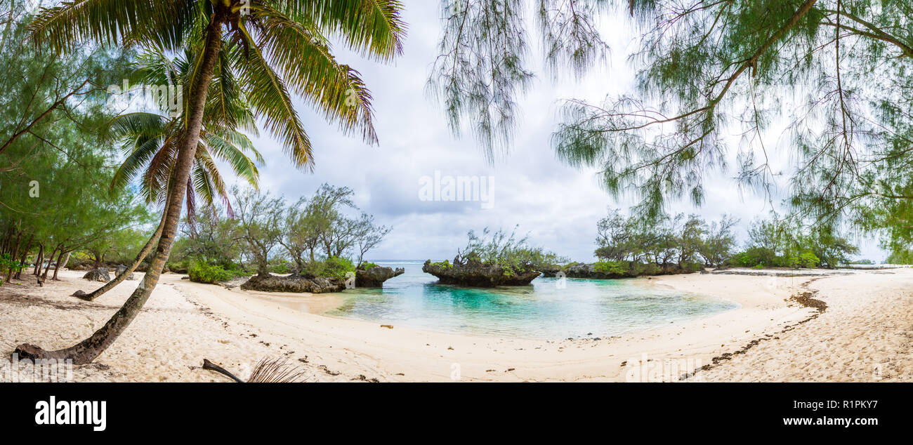 Vista di giallo sabbia bianca spiaggia tropicale sotto le palme in una baia isolata con pietre coralline. Rimatara Island Isole Australi, Polinesia francese. Foto Stock