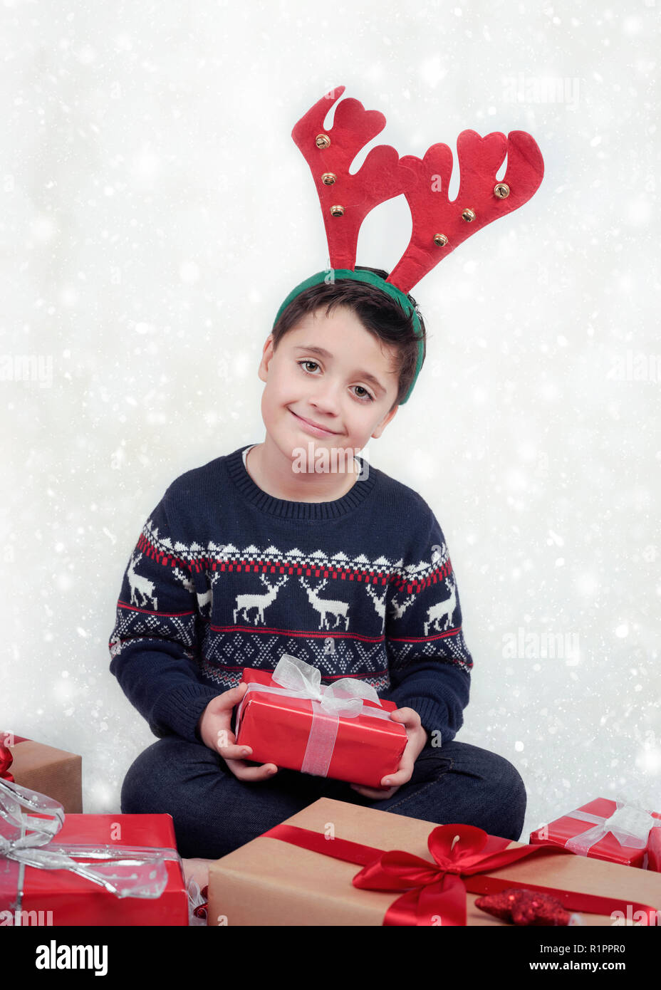 Bambino indossando corna di renne e regali di Natale Foto Stock