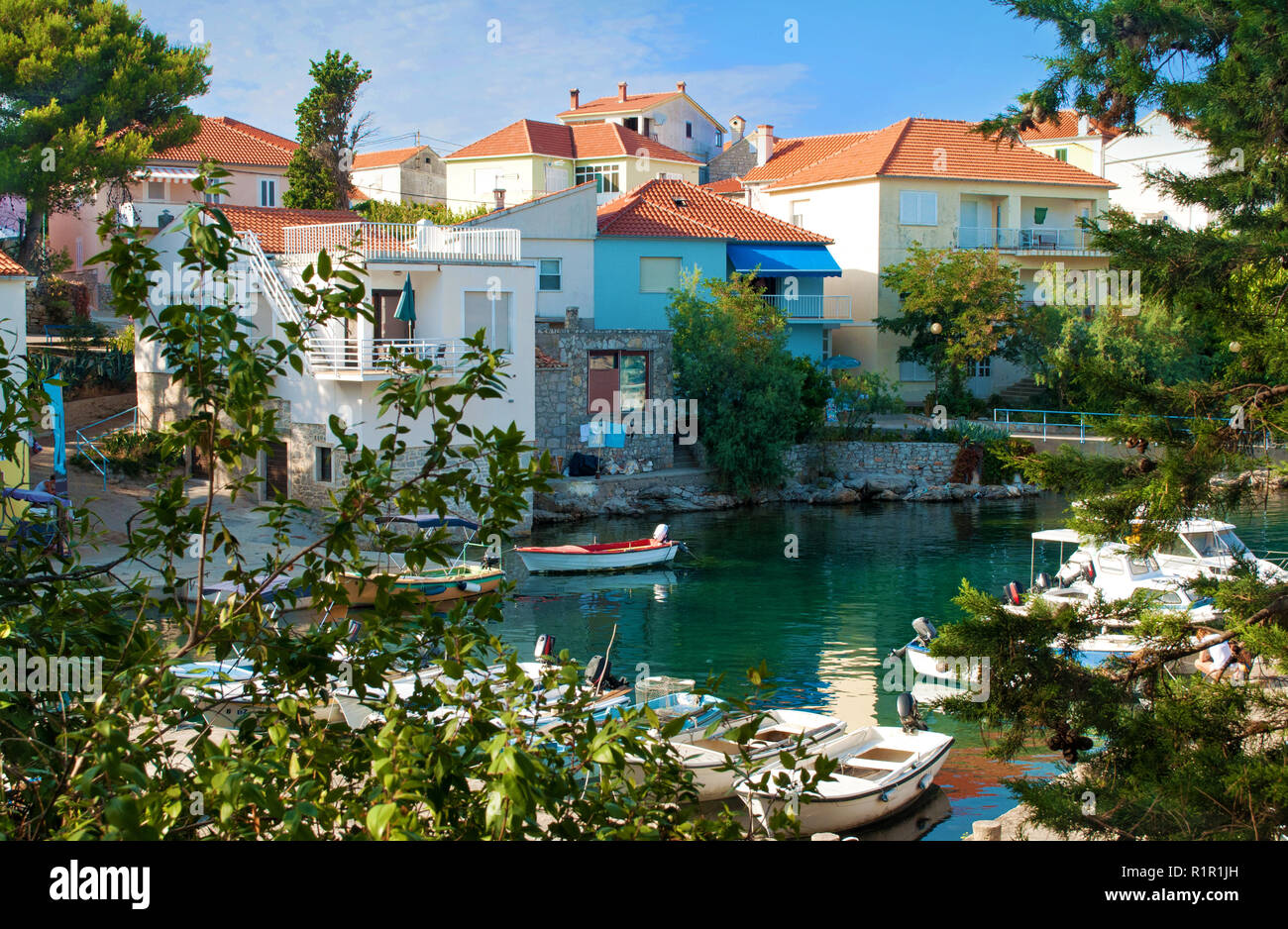 Accogliente e pittoresca cittadina di Bozava, Dugi otok croazia. Piccole case colorate in prossimità di acqua verde smeraldo dove barche e yacht sono flottanti. Tutto fr Foto Stock