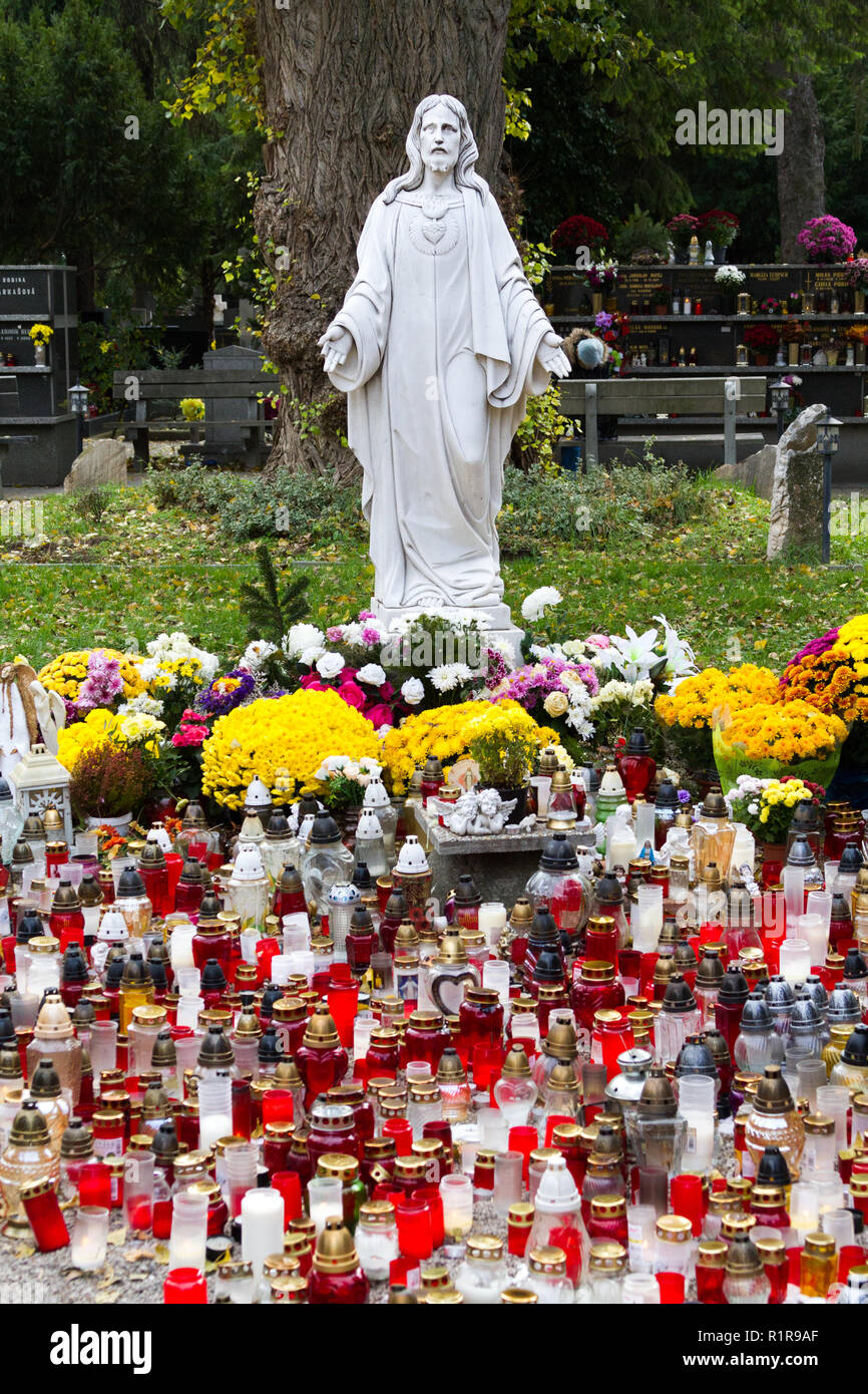Una statua del Sacro Cuore di Gesù a Martinsky cintorin (cimitero) durante le tutte le anime ottava. Accendere le candele di fronte ad esso. Foto Stock