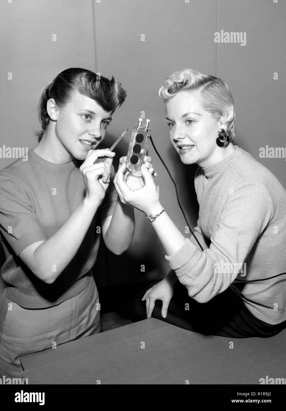 Due donne esaminare un inizio di cella solare, ca. 1955. Foto Stock