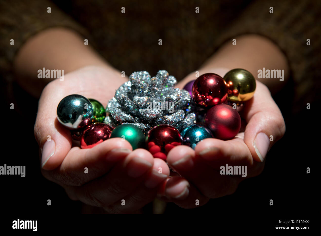Angolo di alta vista delle palle di Natale in mani a tazza Foto Stock