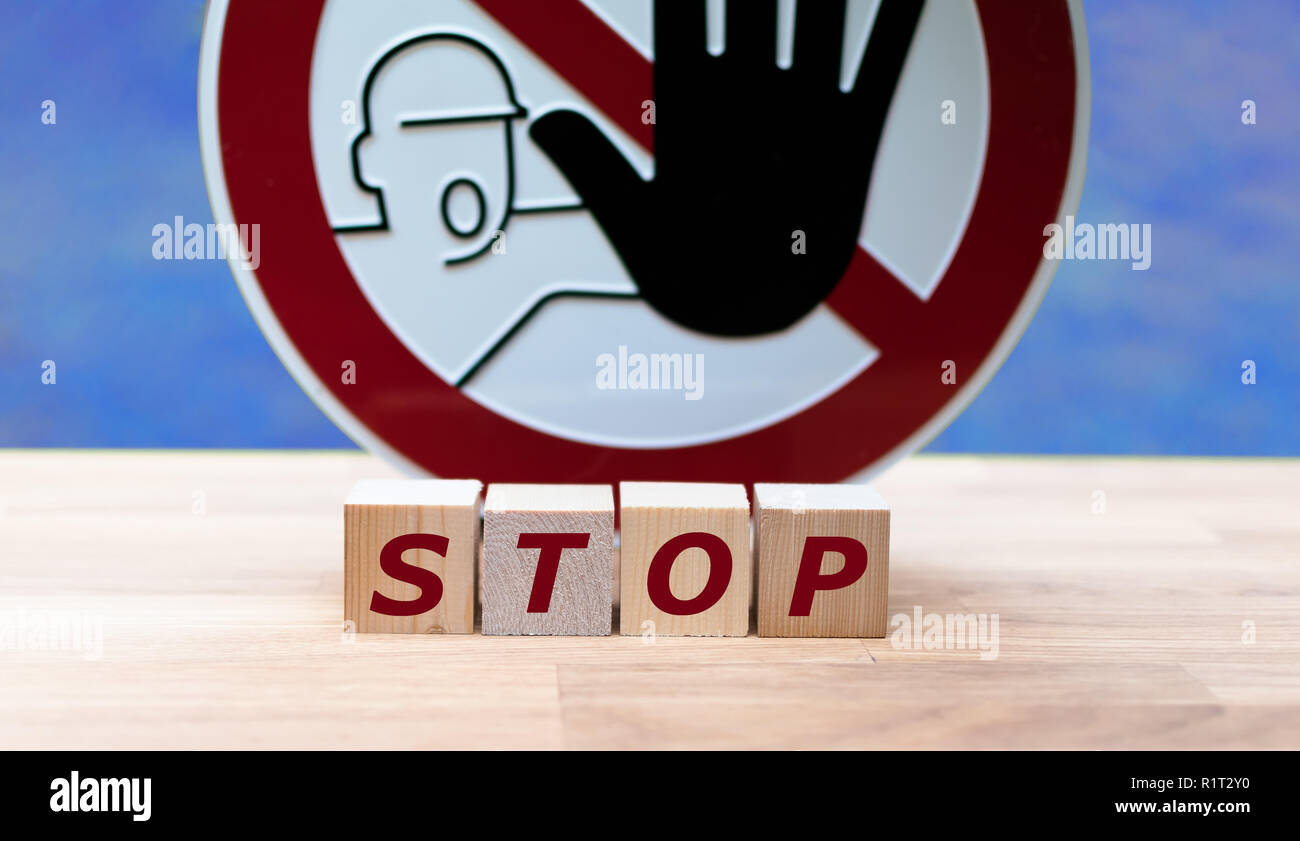 Dadi formante la parola 'stop' davanti ad un segnale di stop Foto Stock