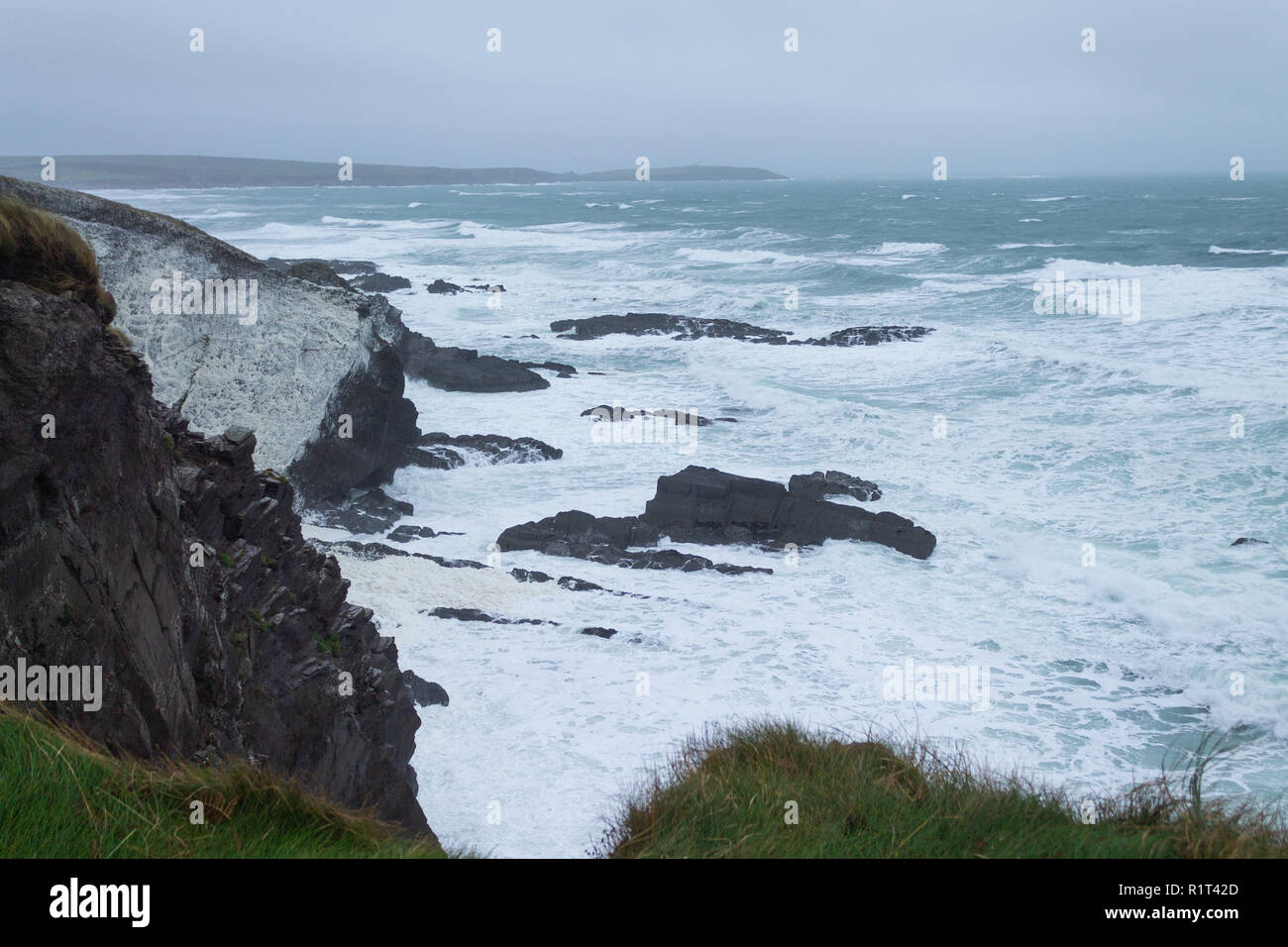 Mare mosso a copertura della scogliera in schiuma di mare da una tempesta. West Cork in Irlanda Foto Stock