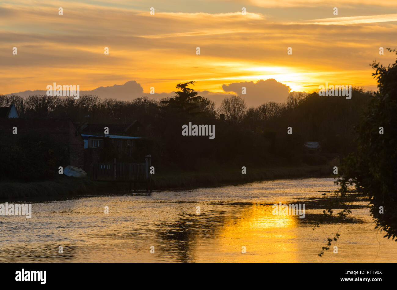 Sun andando verso il basso in un giorno nuvoloso sul fiume Arun in autunno in Arundel, West Sussex, in Inghilterra, Regno Unito. Foto Stock