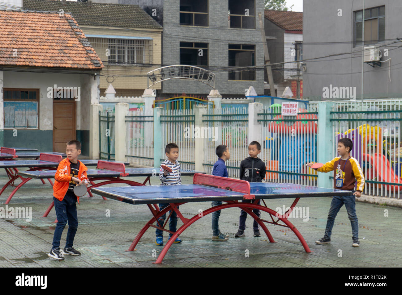 I bambini in Cina giocando a ping-pong presso la scuola primaria Foto Stock