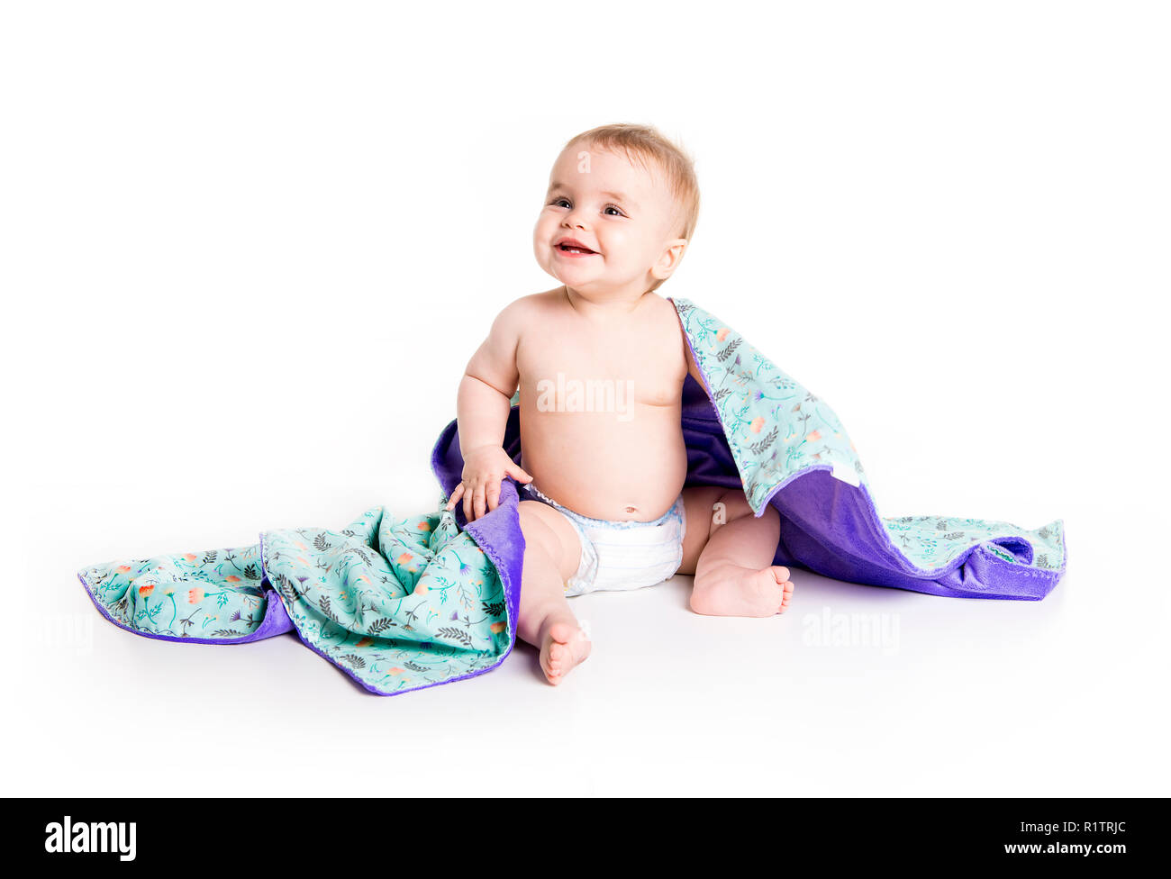 Il bambino sotto un asciugamano. Età di dieci mesi. Esso è isolato su sfondo bianco Foto Stock