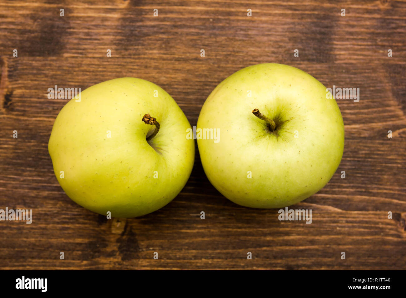 Due mele giallo su un tavolo di legno è vista dal di sopra Foto Stock