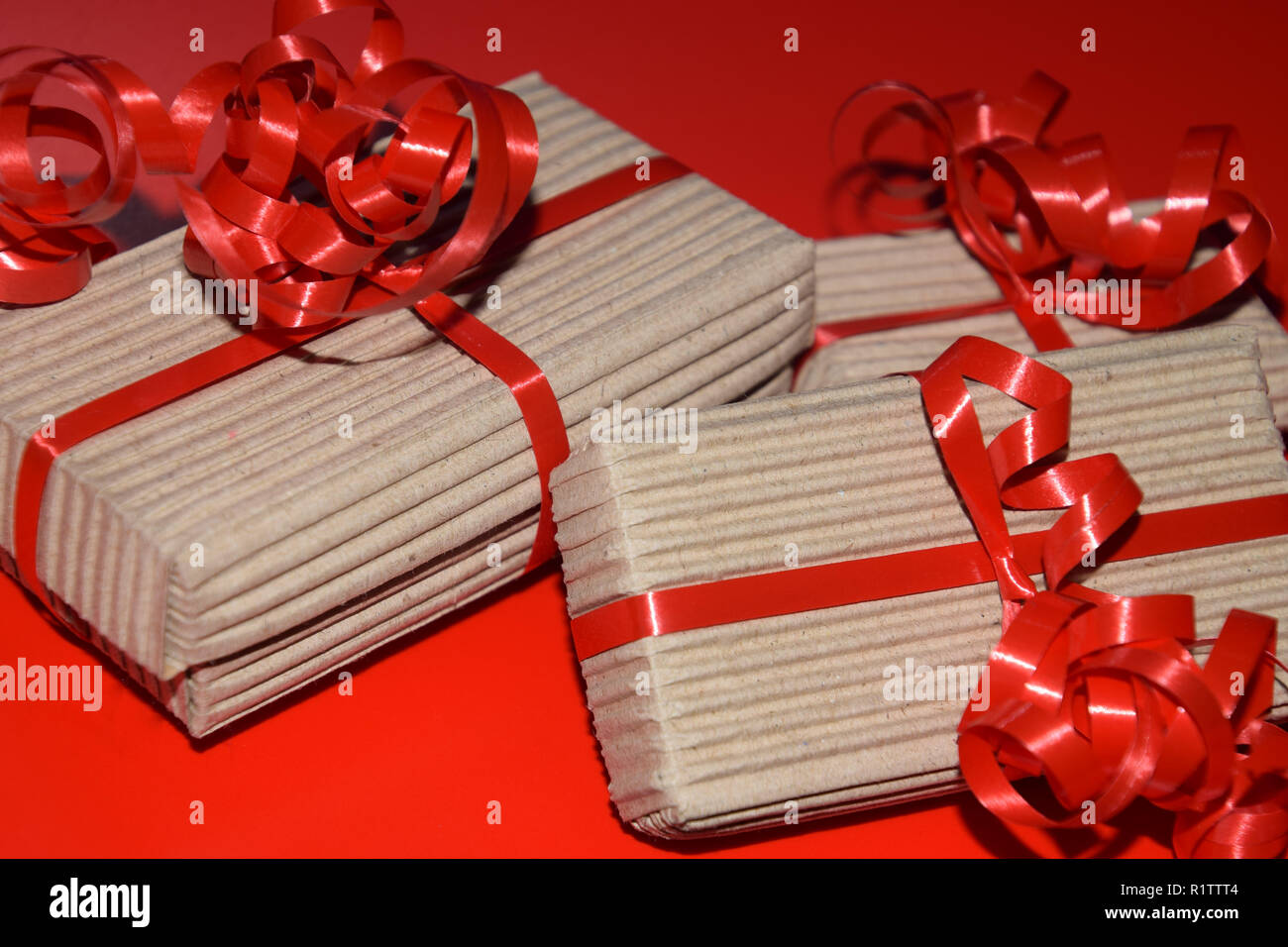 Compleanno o regalo di Natale scatole, vista dall'alto della confezione regalo confezionate in imballaggi di cartone con nastro rosso sulla superficie rossa Foto Stock