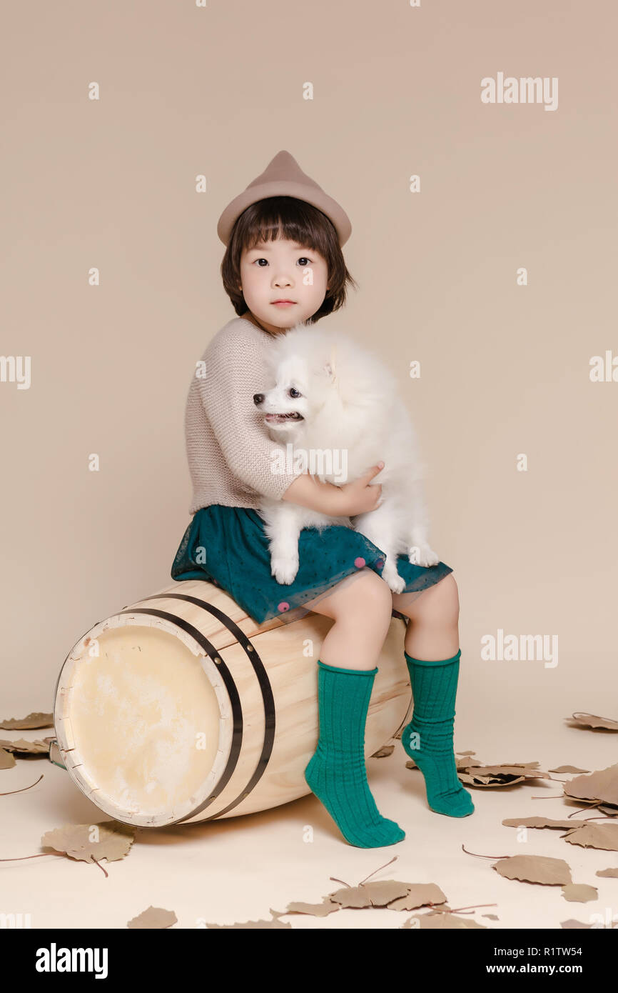 Poco bella ragazza asiatica seduto in un autunno sfondo. Foto Stock