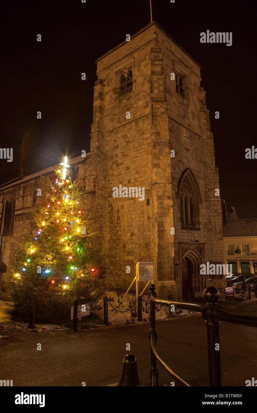 St Michaels chiesa parrocchiale a Malton, North Yorkshire a Natale con un albero illuminato fuori dalla chiesa Foto Stock