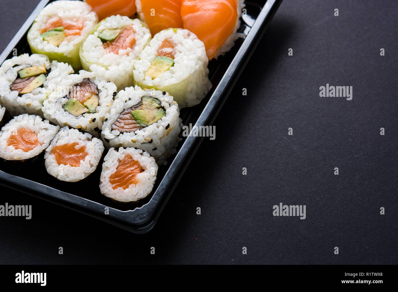 Il cibo giapponese: maki e nigiri sushi set su sfondo nero. Copyspace Foto Stock