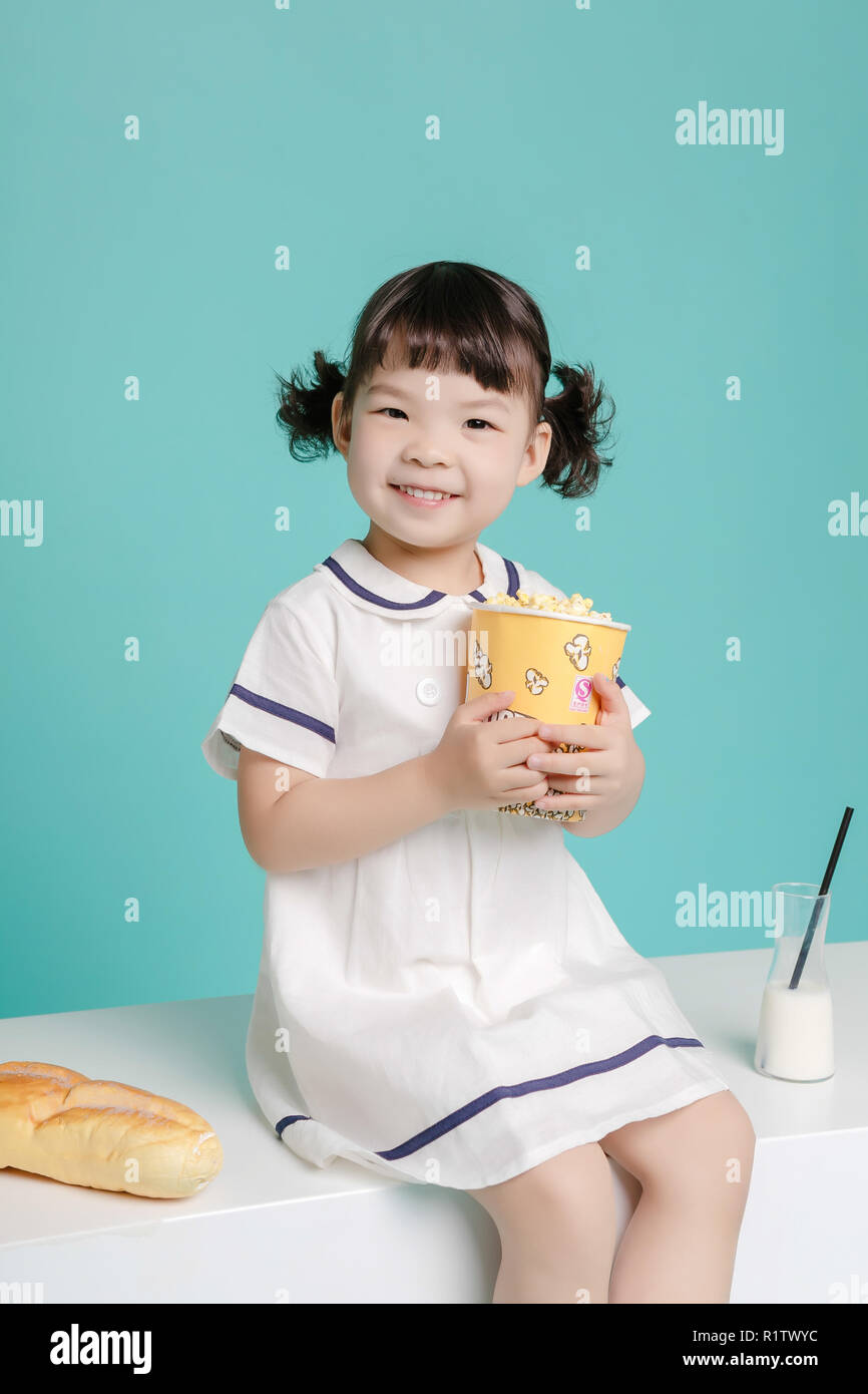 Poco bella ragazza asiatica di ridere ritratto con latte e pane, lifestyle sano e felice. Foto Stock