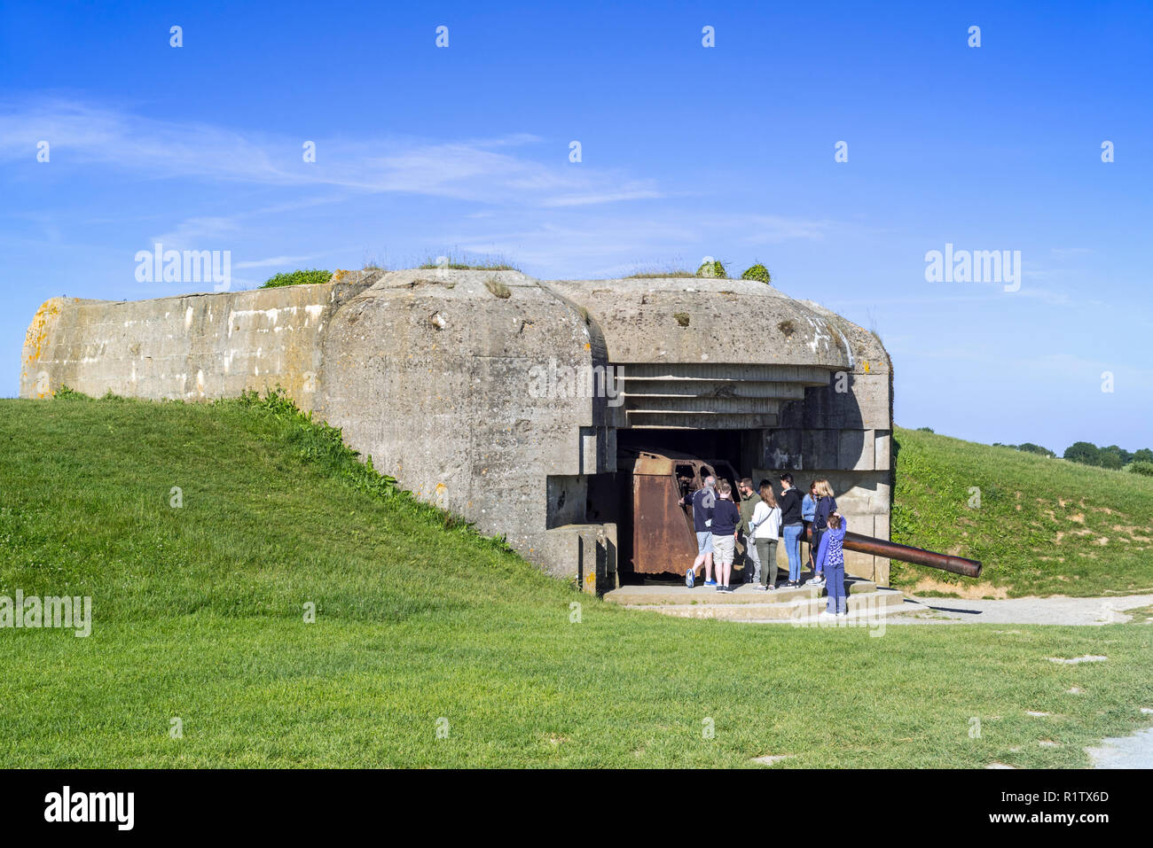 I turisti con la guida visitare bunker della batteria Le Chaos, parte dell'Atlantikwall a Longues-sur-Mer, Normandia, Francia Foto Stock