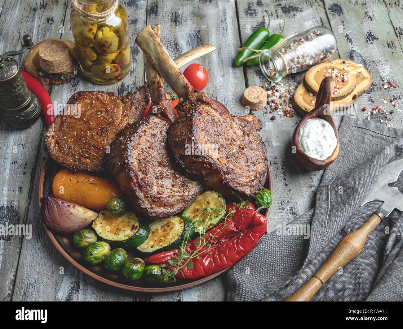 Grigliata di agnello arrosto,montone costolette di carne con verdure sulla piastra . Rustico concetto alimentare Foto Stock