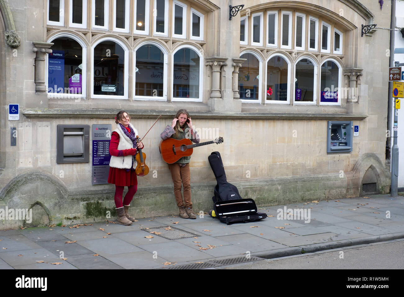 Artisti di strada la riproduzione di musica e canto in high-street in pozzetti, Somerset, Regno Unito Foto Stock