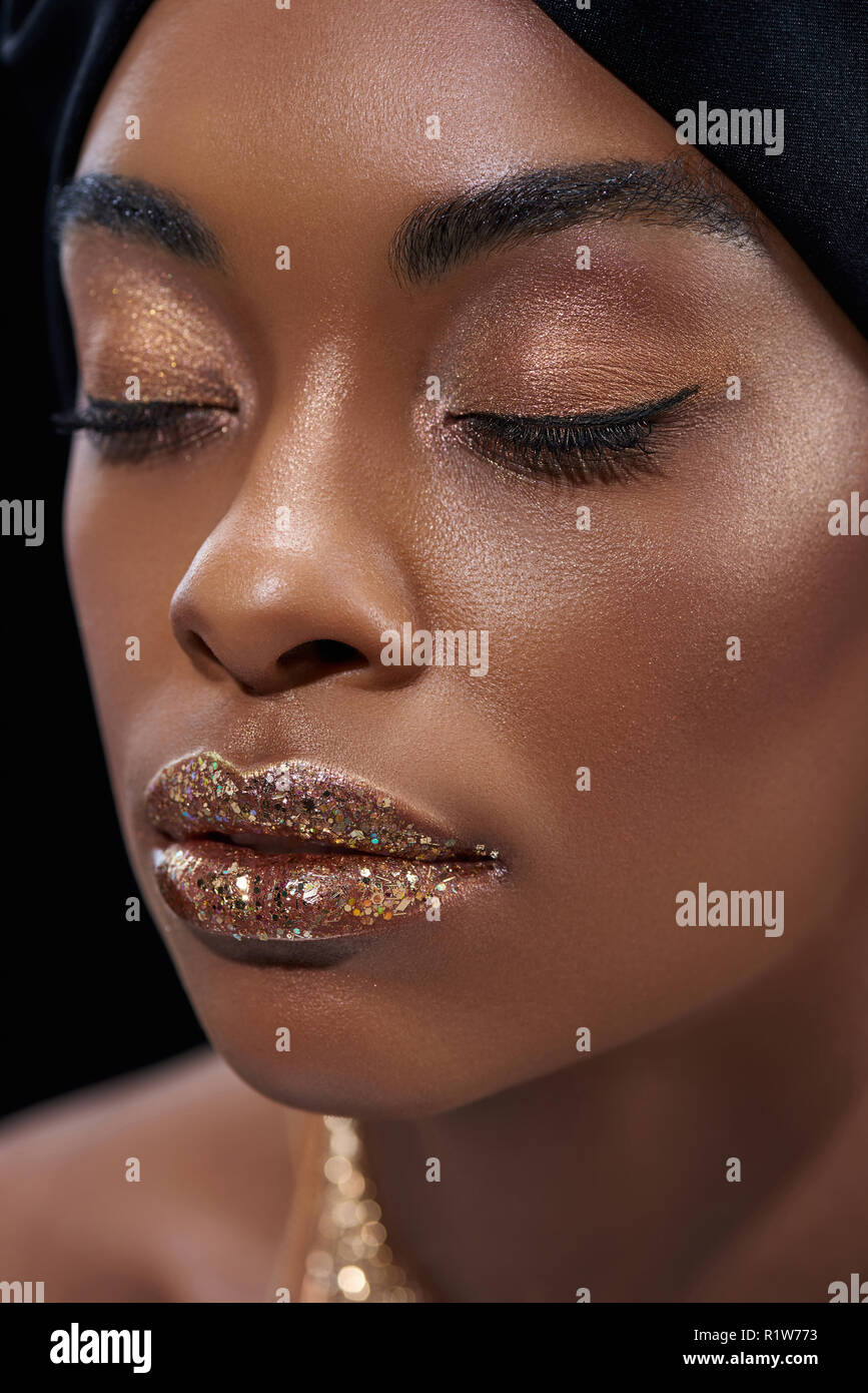 Ritratto di bella americano africano donna con gli occhi chiusi isolato su nero Foto Stock