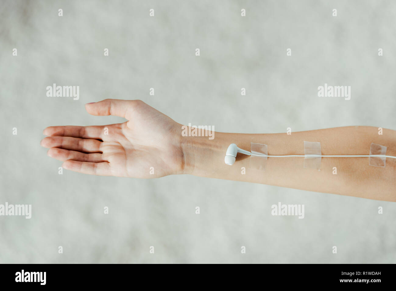 Stretta di mano femmina con auricolare bianco come medico di infusione IV, il concetto di musica Foto Stock