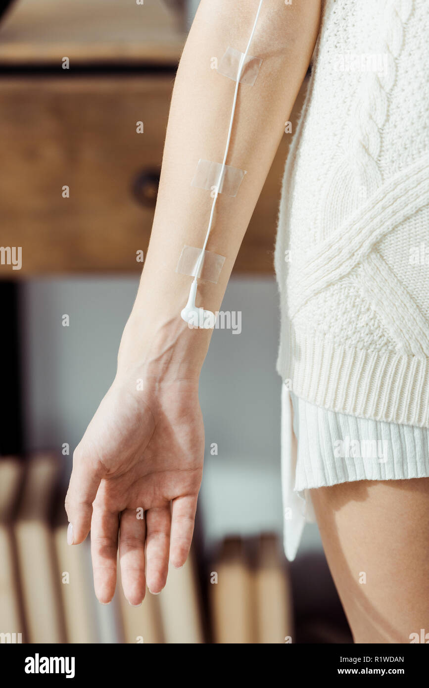 Stretta di mano femmina con auricolare bianco come medico di infusione IV, il concetto di musica Foto Stock