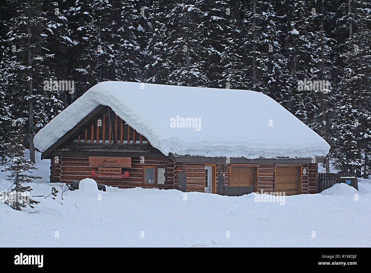 Cabina in montagna con spessi strati di neve sul tetto Foto Stock