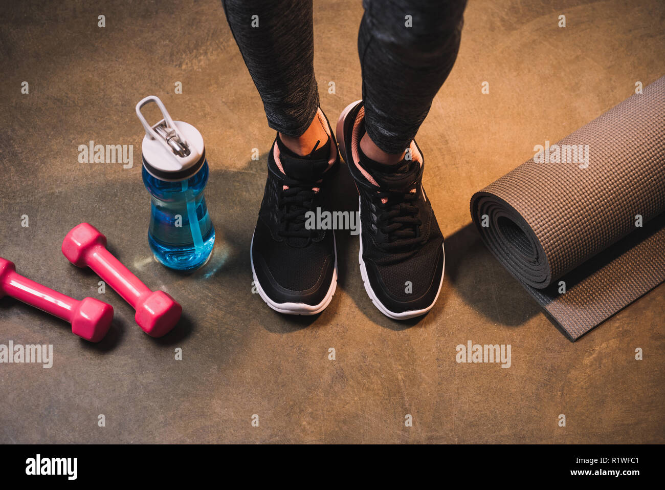 Vista ritagliata della gambe femmina con attrezzature sportive Foto Stock