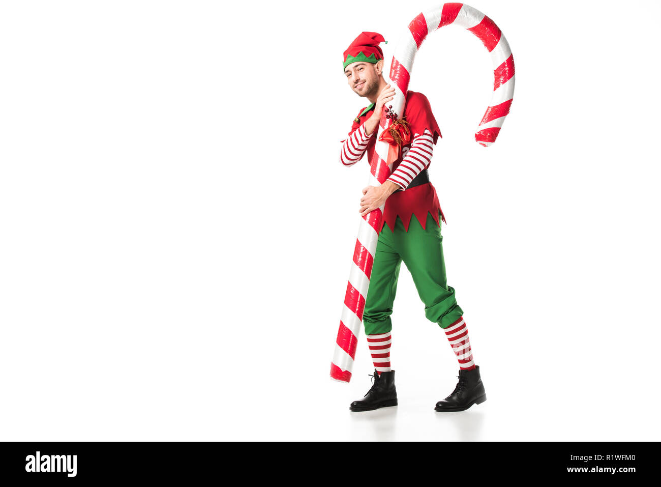 Uomo in elf natale porta costume big candy cane isolato su bianco Foto Stock