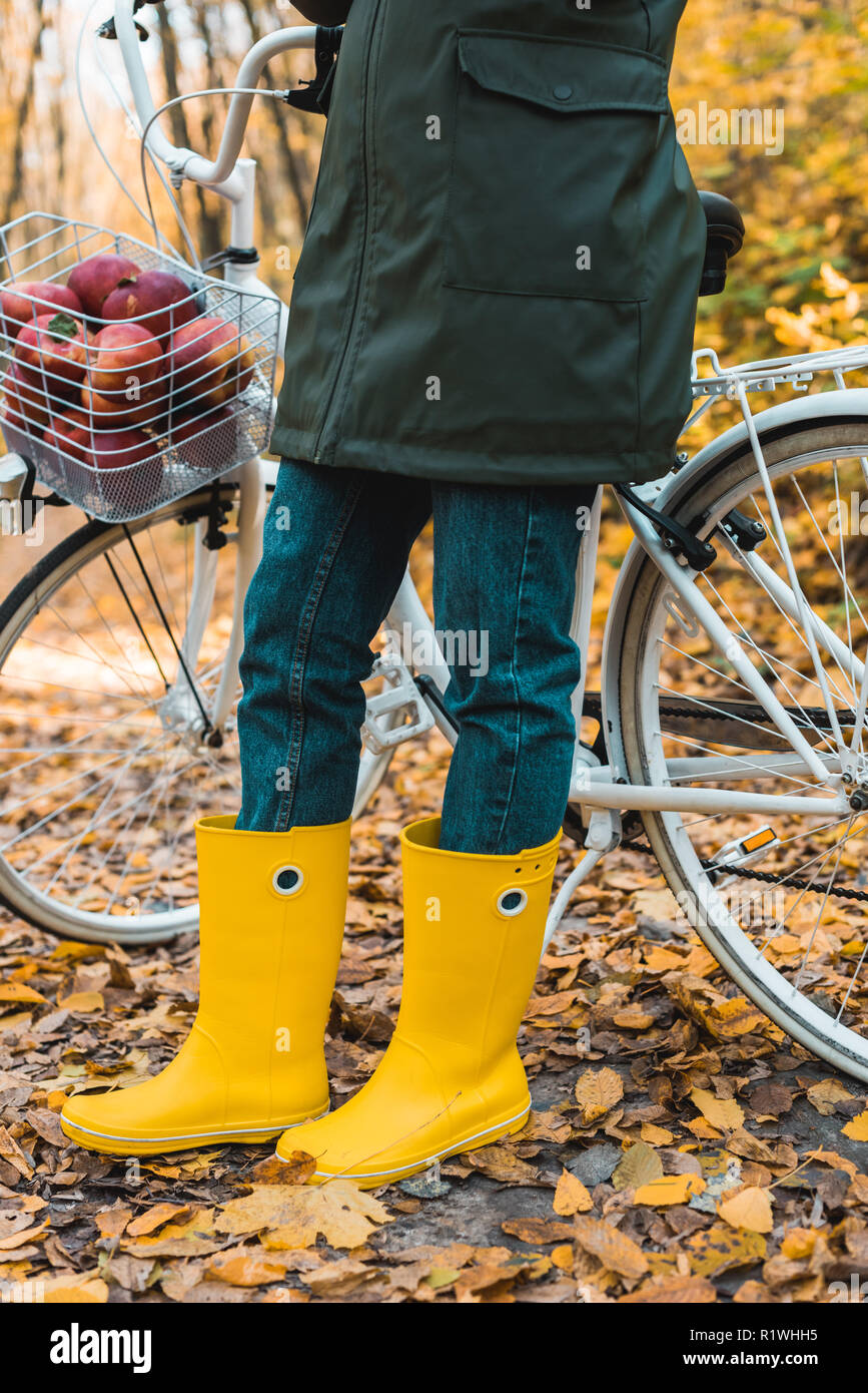 Donna con stivali in gomma gialla e impermeabile in piedi con la borsa nel  corridoio a casa, pronto a camminare all'esterno in caso di pioggia Foto  stock - Alamy