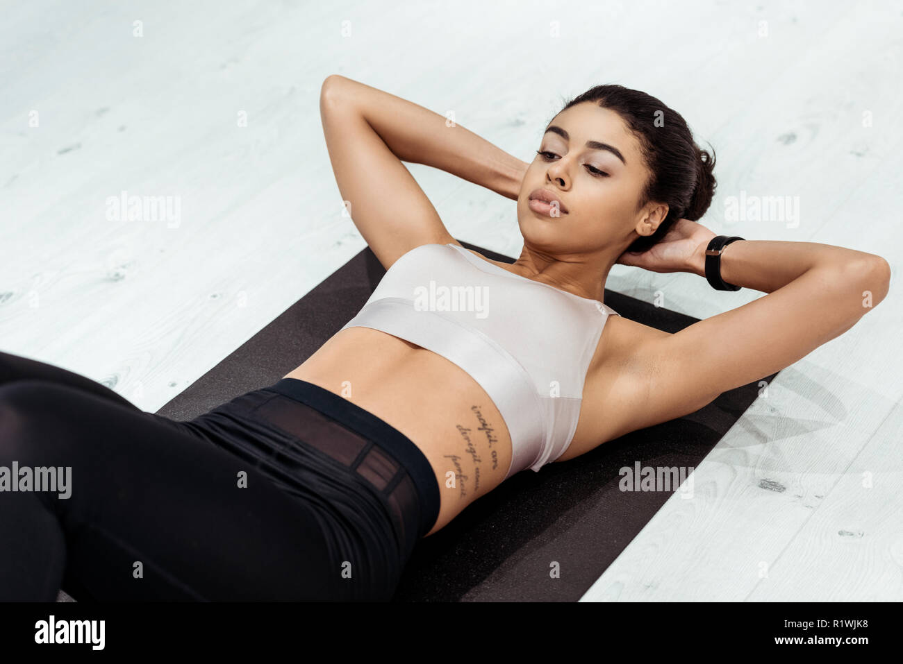 Splendida femmina sportive facendo abs sul tappetino fitness Foto Stock