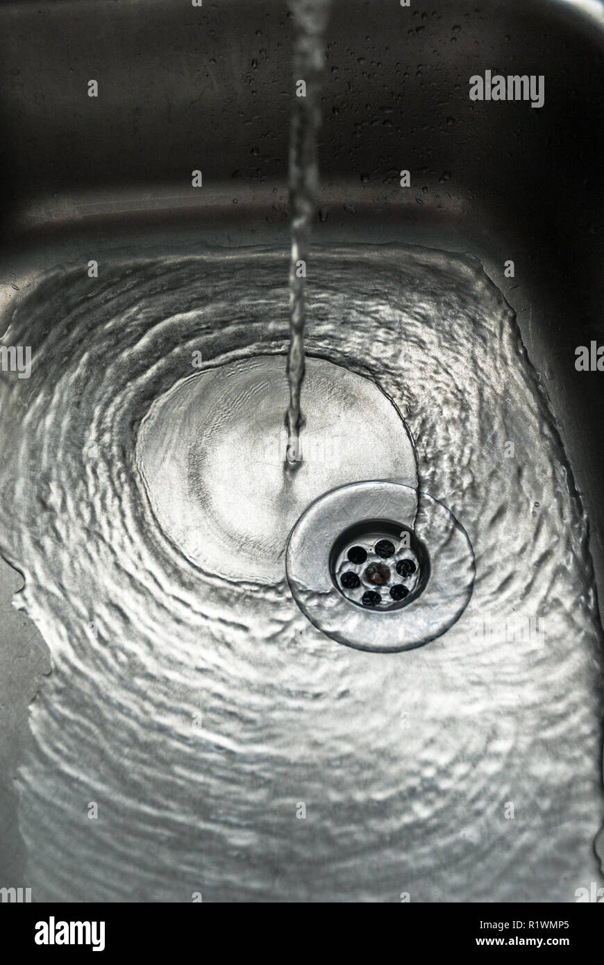 Chrome lavello con acqua di versamento. Foto Stock
