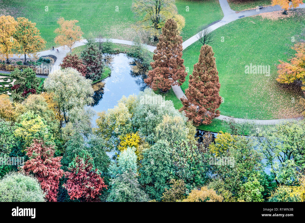 Vista aerea di vari alberi in vari colori autunnali, sentieri tortuosi, manti erbosi e un laghetto nel parco un parco pubblico a Rotterdam, Nethe Foto Stock