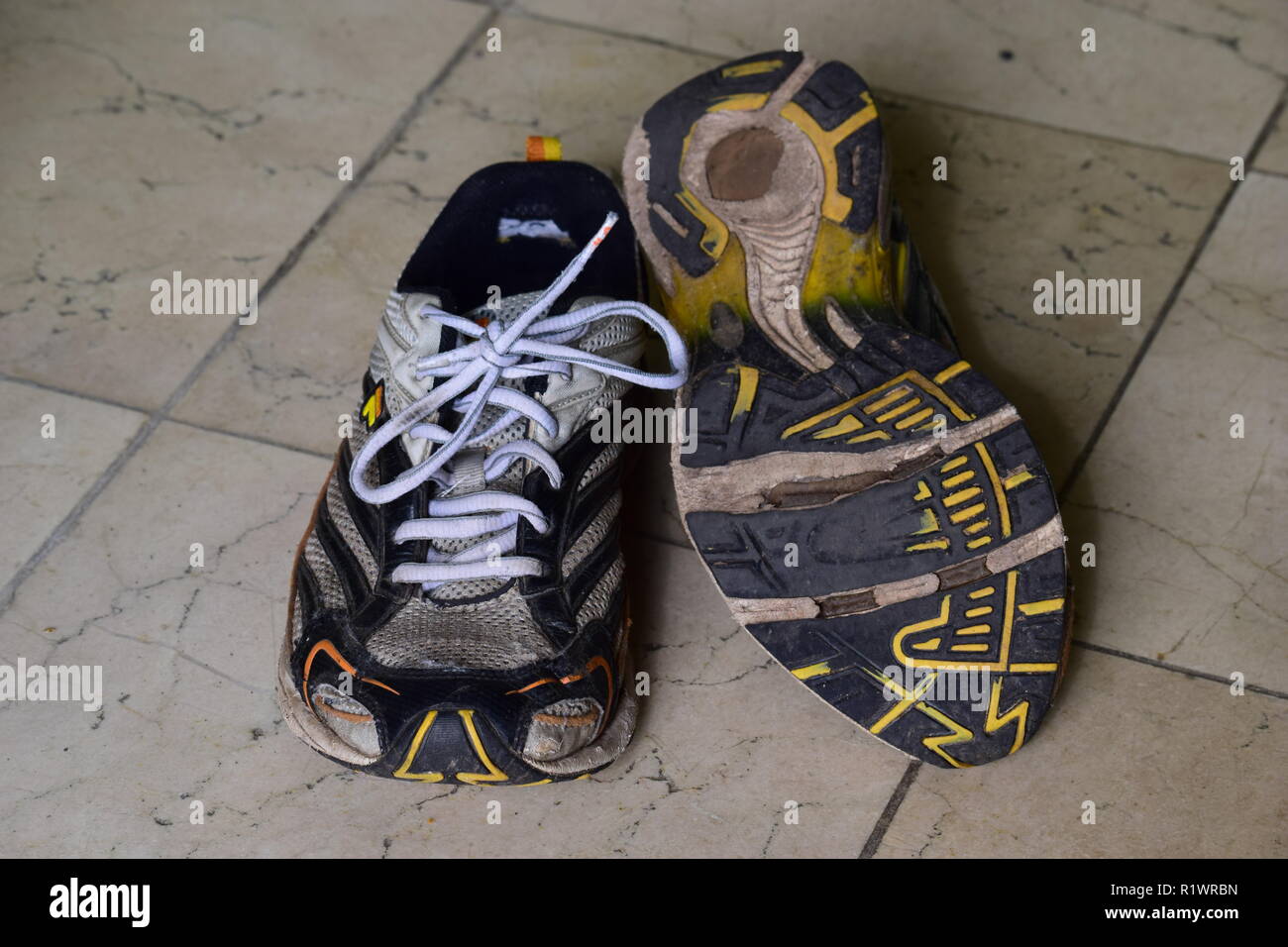 Coppia di vecchi Esegui e scarpe logore e con fori sotto la suola. Paar alte Lauf- und Wanderschuhe abgenutzt und mit Löchern unter der Sohle Foto Stock