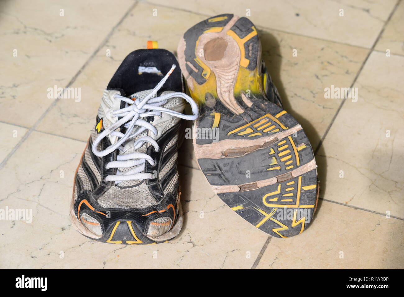 Coppia di vecchi Esegui e scarpe logore e con fori sotto la suola. Paar alte  Lauf- und Wanderschuhe abgenutzt und mit Löchern unter der Sohle Foto stock  - Alamy