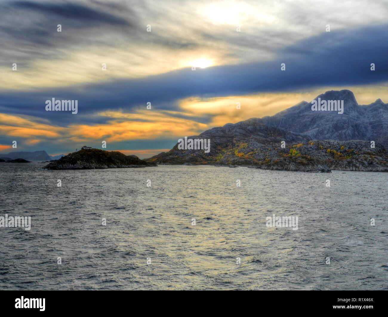 Piccola isola della costa norvegese sotto un cielo strano, Norvegia Foto Stock