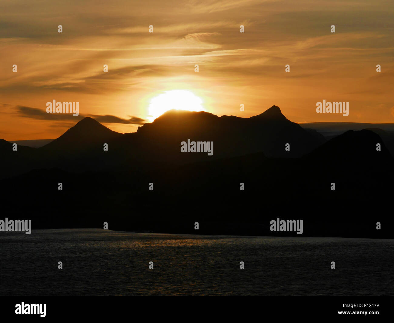 Il sole sorge dietro la montagna e i fiordi in Norvegia, vista durante una crociera Hurtigruten Foto Stock