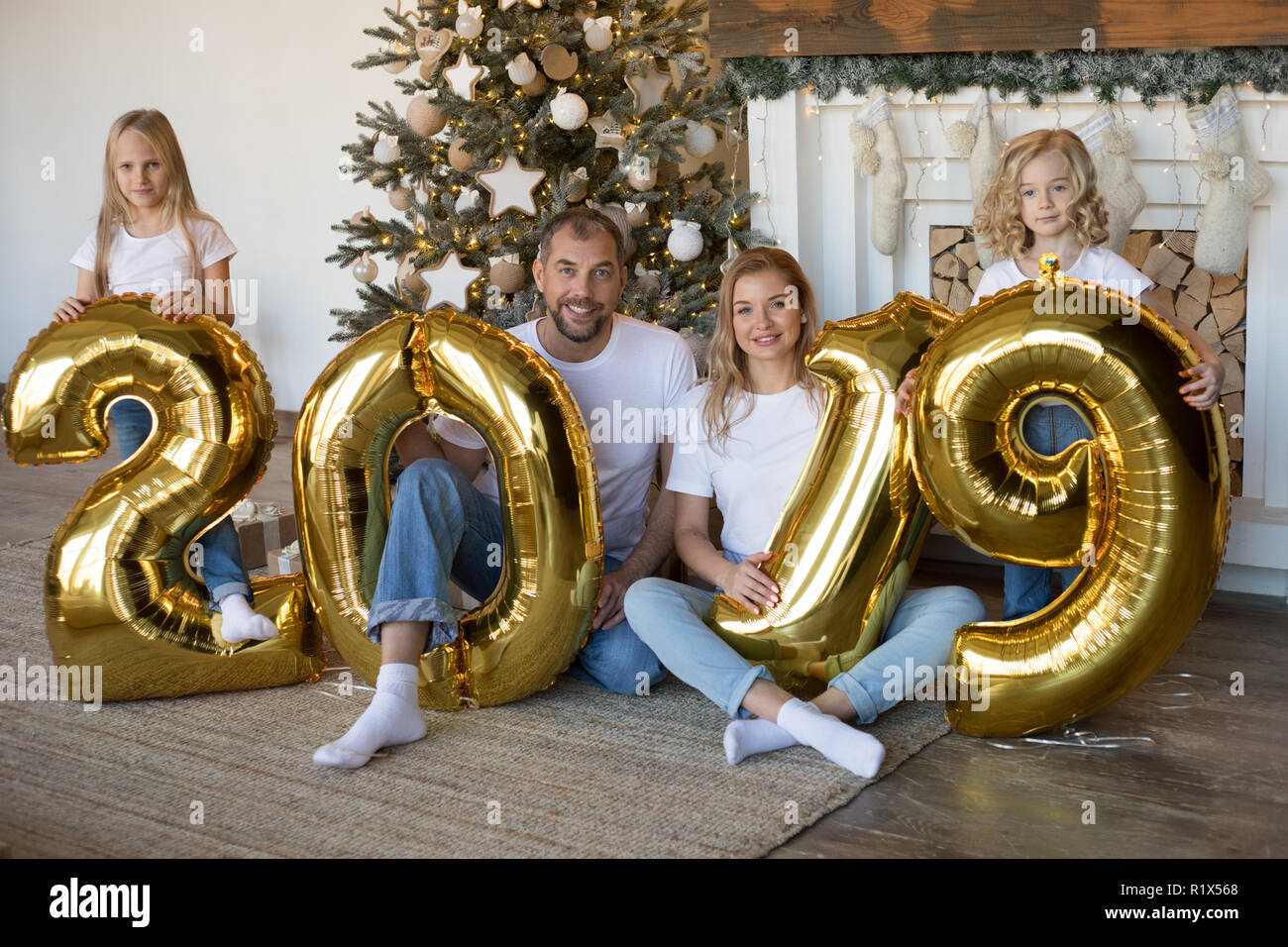 La famiglia felice Holding firmano 2019 fatta di palloncini d'oro per il nuovo anno. Foto Stock