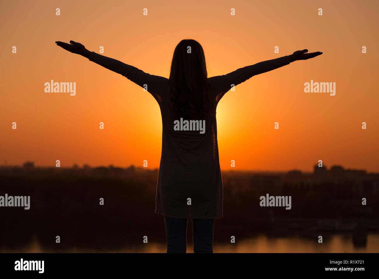 Silhouette di donna meditando al tramonto. Foto Stock