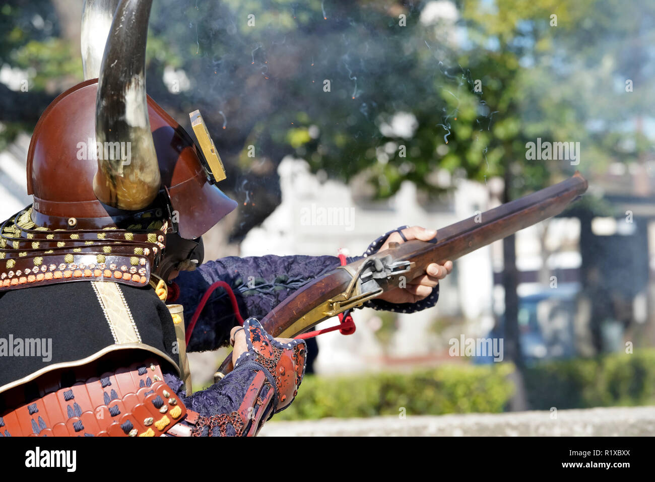 Samurai Giapponese di abbigliamento yoroi e kabuto uniforme con il vecchio cannone Foto Stock