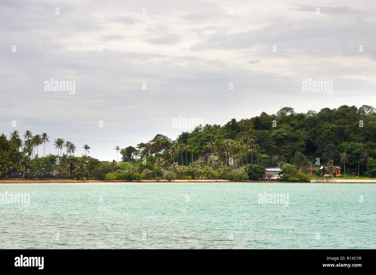 Paesaggio tropicale con ambra spiaggia di sabbia e rocce, palme di cocco e il turchese mare tropicale di Koh Chang Island in Thailandia Foto Stock