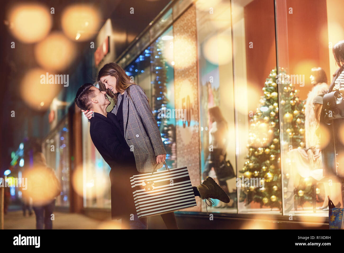 Una giovane coppia con pacchetti di shopping è il giorno di Natale. Foto Stock