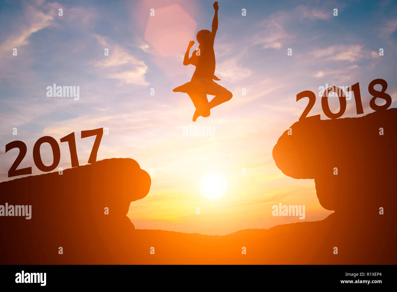 Silhouette di uomo felice salto tra 2017 e 2018 anni nel tramonto. Foto Stock