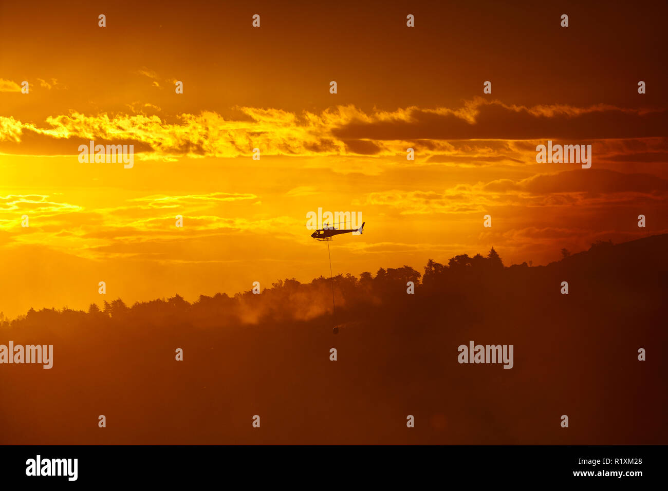 Smokey tramonto e elicottero antincendio a Burnside, Dunedin, Isola del Sud, Nuova Zelanda Foto Stock