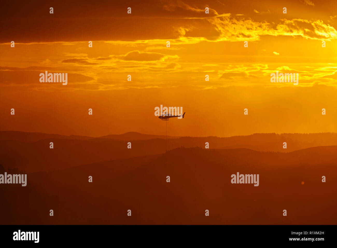 Smokey tramonto e elicottero antincendio a Burnside, Dunedin, Isola del Sud, Nuova Zelanda Foto Stock