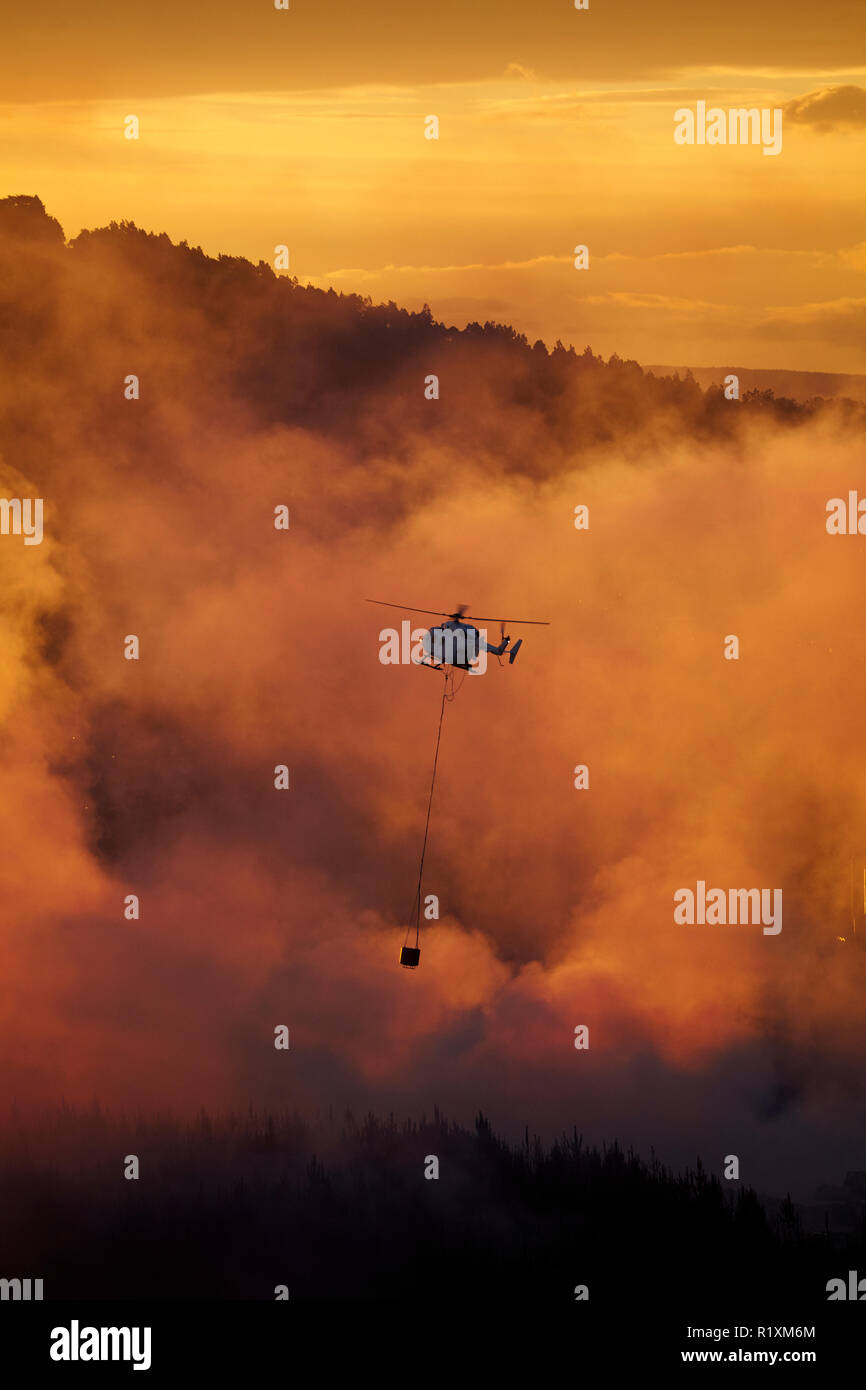 Smokey tramonto e elicottero antincendio a Burnside, Dunedin, Isola del Sud, Nuova Zelanda Foto Stock