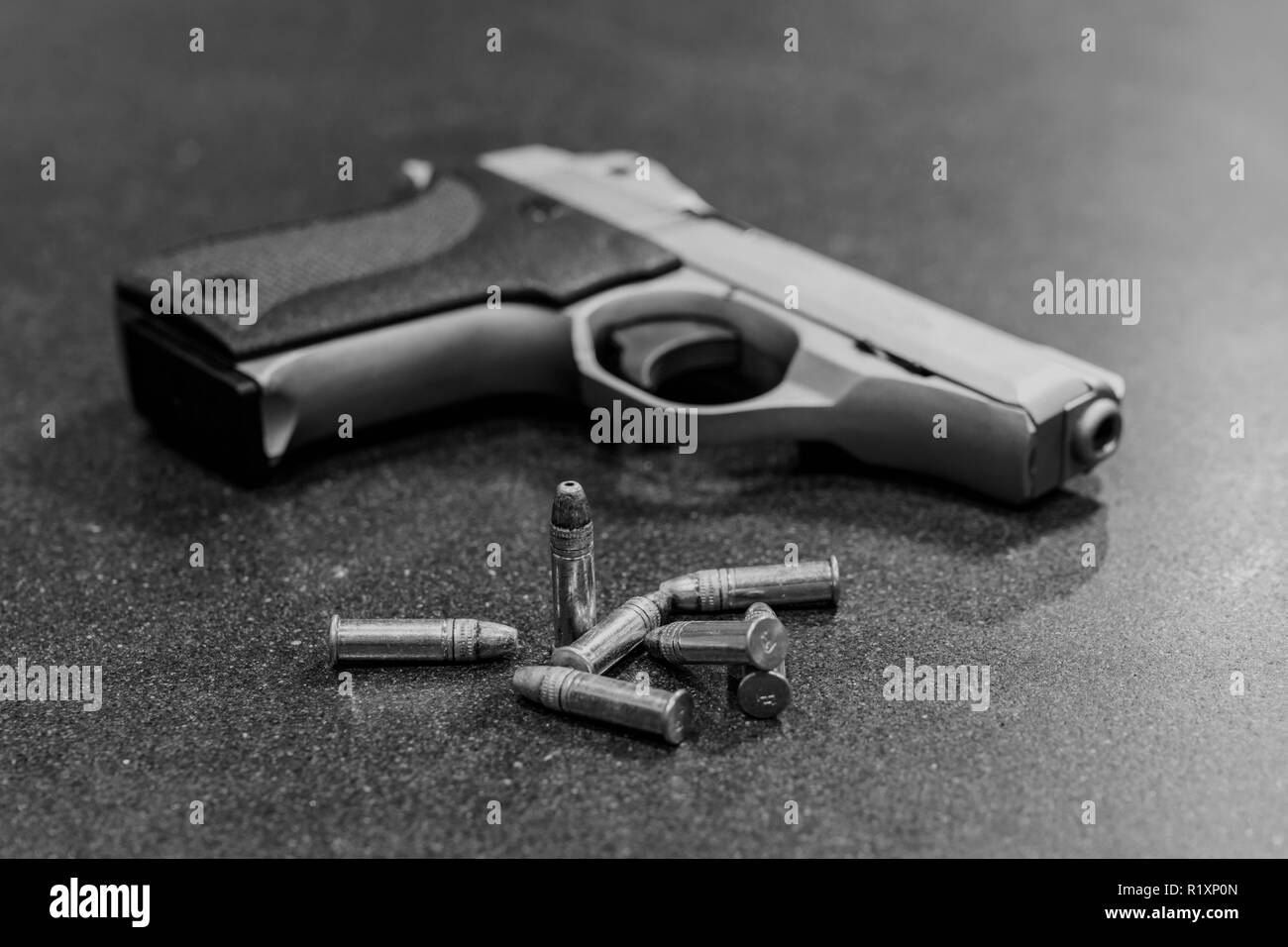 I proiettili e pistola sulla tavola nera Foto Stock